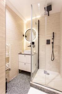 La salle de bains est pourvue d'une douche et d'un lavabo. dans l'établissement CMG Résidence Canal Saint-Martin / Vellefaux, à Paris