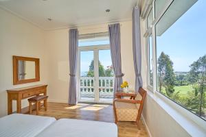Villa Paradise Mui Ne في موي ني: غرفة نوم بسرير ونافذة كبيرة