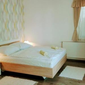 łóżko z białą pościelą i poduszkami w sypialni w obiekcie Lavender Apartment w Hévízie
