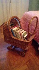 uma cesta cheia de livros sentados num chão de madeira em B&B Appia Felis em Roma