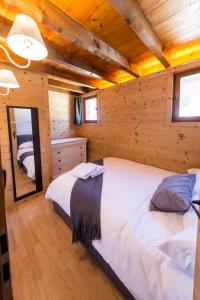 Dormitorio en cabaña de madera con 2 camas y espejo en Close to the village - Chalet 4 Bedrooms, Mont-Blanc View en Megève