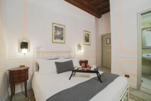 a bedroom with a white bed with a tray on it at La Maison Dell'Orologio in Rome