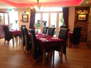 a dining room with a red table and chairs at The Waterwheel in St Austell