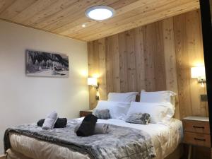 a bedroom with a large bed with wooden walls at Magnifique Appartement neuf de 60m2 Méribel centre in Les Allues