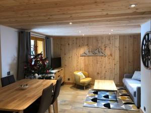 uma sala de estar com uma mesa e uma árvore de Natal em Magnifique Appartement neuf de 60m2 Méribel centre em Les Allues