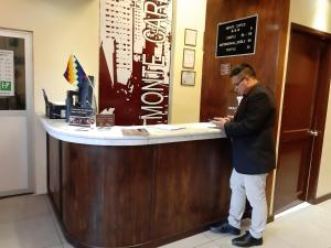 a man is standing at a counter in a restaurant at Hotel Monte Carlo in La Paz