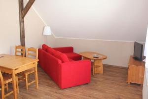 salon z czerwoną kanapą i stołem w obiekcie Słoneczna Zagroda - Sunny Ridge Farm w mieście Łączna