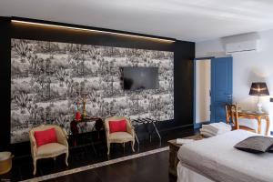 カターニアにあるB&B SEKELES Suites and Spaの壁画のあるベッドルーム(テーブル、椅子付)