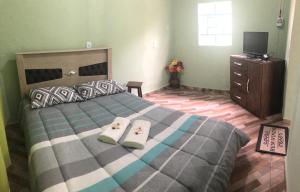 a bedroom with a bed with two towels on it at Cantinho de Serra in Cunha