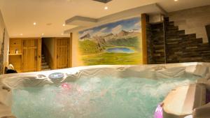 a jacuzzi tub in a bathroom with a painting at Chalet les trois coeurs in Méribel +25 photos