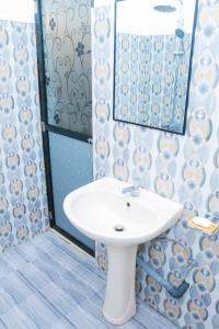 ein Badezimmer mit einem weißen Waschbecken und einem Spiegel in der Unterkunft Beach Breeze Weligama in Weligama