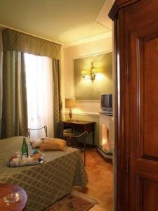 a bedroom with a bed and a table and a window at Petit Chateau in Montecatini Terme