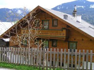 ein Holzhaus mit einem Zaun davor in der Unterkunft Bergbauernhof Untermoos in Taxenbach