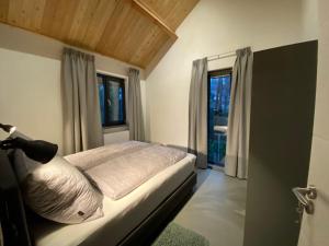 1 dormitorio con cama y ventana en Apartmentshaus Dual - 2 en Hermagor