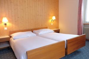 um quarto com uma cama grande e 2 almofadas brancas em Guest Rooms with a great view at Residence Brunner em Wengen