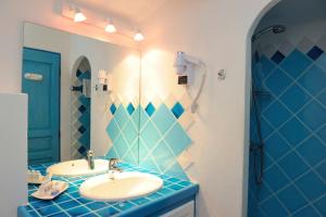 a blue and white bathroom with two sinks and a shower at Résidence Belvedere de Palombaggia in Porto-Vecchio