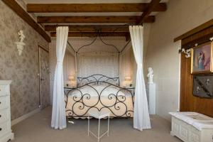 a bedroom with a large bed with curtains in it at Les charmes in Valençay