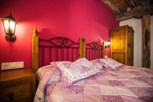 ein Schlafzimmer mit einem Bett mit einer rosa Wand in der Unterkunft Arkaitza in Berrobi