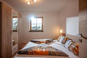 a bedroom with two beds and a window at Appartements Höpfl in Westendorf