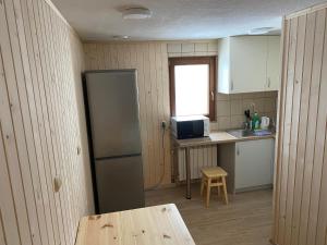 a kitchen with a refrigerator and a table and a window at Willa Huragan in Bukowina Tatrzańska