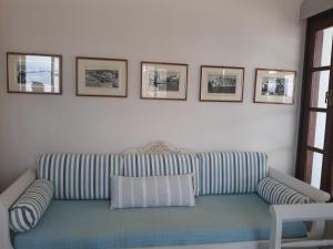 Eftychias residence في ماسوري: غرفة معيشة مع أريكة مخططة وصور على الحائط