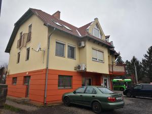 a green car parked in front of a house at Berik Apartman in Pécs