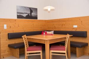 a wooden table with two chairs and a table with at Apartment Erler in Hippach