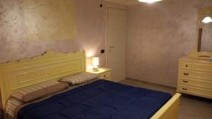a bedroom with a blue bed and a dresser at Ca' Nova in Roccaforte Mondovì