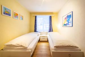 2 Betten in einem Zimmer mit Fenster in der Unterkunft Via Sulten 12 in Flims