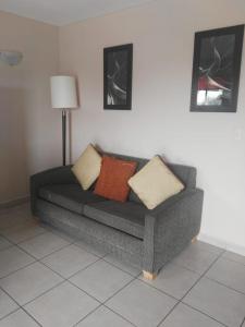 a couch in a living room with pillows on it at Los Jitos Hotel & Suites in San Carlos