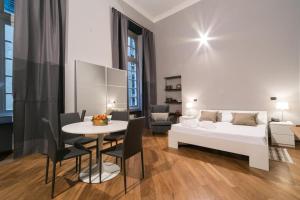 1 dormitorio con 1 cama, mesa y sillas en Chiossone Suites, en Génova