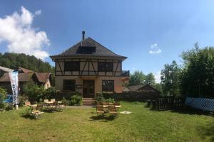 a house with chairs and tables in a yard at Chambre double dans Auberge Alsacienne in Scherwiller