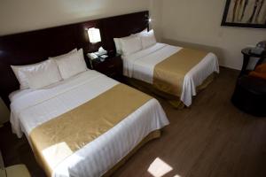 a hotel room with two beds and a telephone at Best Western Centro Monterrey in Monterrey