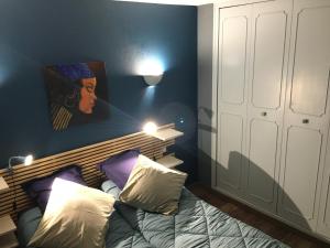 AU PIED DU VERCORS TOUT EST PERMIS في La Rivière: غرفة نوم بسرير مع لوحة على الحائط