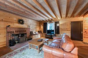 a living room with a leather couch and a fireplace at Elevation Station in Shaver Lake