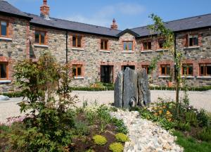 un edificio in pietra con una statua davanti di Decoy Country Cottages a Navan