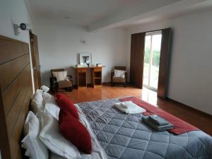 een slaapkamer met een bed, een tafel en een bureau bij Paraíso Hills - Encostas do Paraíso: tranquilidade no Douro in Resende