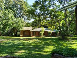 Puerto ParanayComplejo Paranay的一座有树木和草地的院子的房子