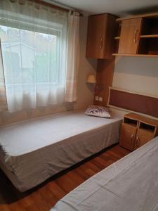 a large bed in a room with a window at Pyla Chalet et mobilhom 6 personnes Magda in La Teste-de-Buch