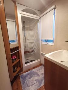 a bathroom with a shower and a tub and a sink at Pyla Chalet et mobilhom 6 personnes Magda in La Teste-de-Buch
