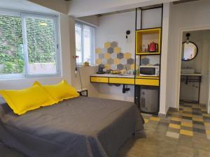 um quarto com uma cama e uma cozinha com um micro-ondas em CASA MARGARITA 4Piso MonoAmarillo em San Salvador de Jujuy