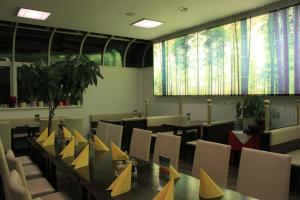 ein Esszimmer mit einem langen Tisch und Stühlen in der Unterkunft Pension & Restaurant TsingDao in Hörbranz