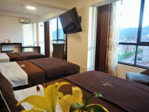 a hotel room with two beds and a large window at San Francisco Cusco Hotel in Cusco