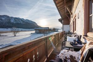 a balcony with tables and chairs on a building at Welzenhof in Walchsee