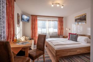 a bedroom with a bed and a desk and a table at Welzenhof in Walchsee