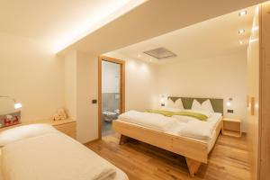 een slaapkamer met 2 bedden en een badkamer bij Piz da Cir in Colfosco