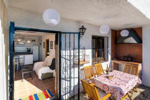 a room with a table and chairs and a kitchen at Casa Consuelo in Capileira