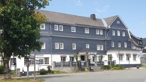 a large blue and white building on a street at Hotel Altastenberg in Winterberg