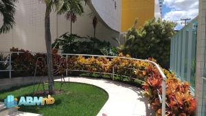 um jardim com flores coloridas e uma passarela em Apto. 1 dormitório no M. de Nassau - Ed. Manhattan Home Service 302 em Caruaru