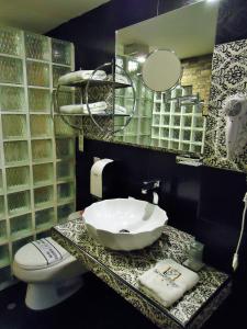 a bathroom with a sink and a toilet and a mirror at Hotel San Francisco Plaza in Cusco